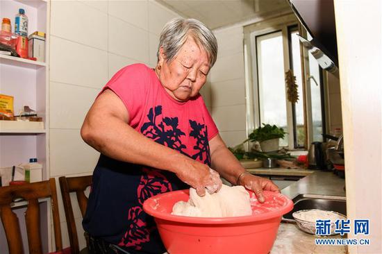 郭永财的老伴冯秀华在新居厨房内做饭（8月11日摄）。新华社记者 刘磊 摄
