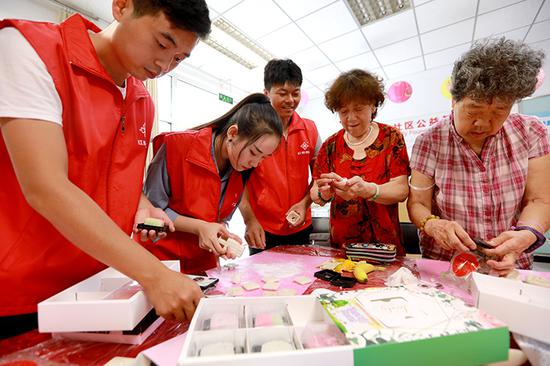 志愿者与社区居民一起做月饼。