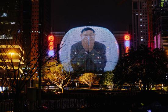 2020年2月10日，徐汇区一家商场的外墙上播放正确佩戴口罩的视频。 澎湃新闻记者 伍惠源 图