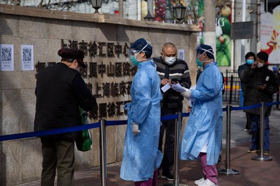 2020年2月10日，上海市徐汇区中心医院外，病人在排队等待。疫情当前，非常时期，各家医院拉起一道道防疫线。除了让就医者在排队时段里就把“流行病调查”表格在手机上完成提交，该院搬来红外体温检测仪，一旦体温“超标”，则设备自动报警，比人工手持体温枪速度更快，也减少人员近距离接触引发交叉感染的可能。澎湃新闻记者 史阳琨 图