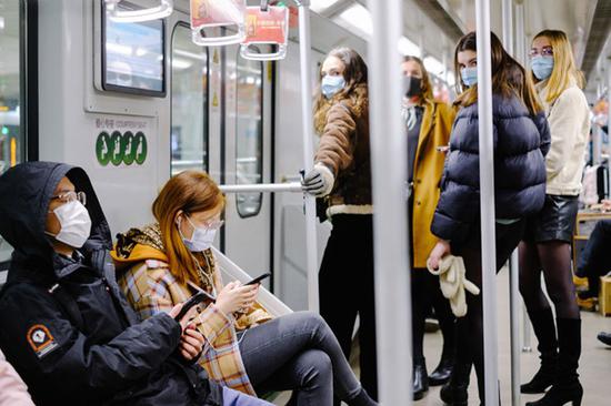 　　2020年2月10日，地铁里戴着口罩的乘客们。自2月5日起，乘坐上海地铁必须佩戴口罩，上海地铁将对未佩戴口罩的乘客进行劝阻。这意味着，不戴口罩就不得进站乘坐地铁。 澎湃新闻记者 伍惠源 图