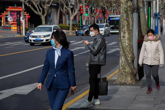 2020年2月10日，人们戴着口罩行走在上海街头。 澎湃新闻记者 史阳琨 图