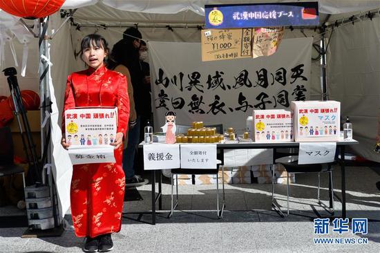 2月8日,在日本东京池袋,一位身着红色旗袍的日本少女手捧募捐箱为武汉募捐。 新华社发(张徽庆摄)