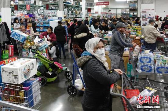 当地时间3月13日，位于美国纽约皇后区的一家大型超市，民众排队购买物资。中新社记者 廖攀 摄