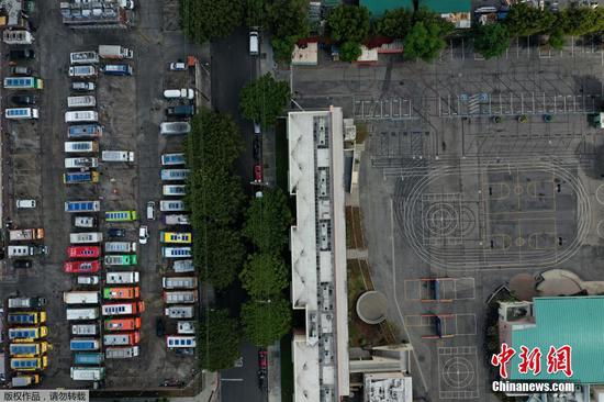 当地时间3月23日,食品卡车停在洛杉矶一所空学校旁边的停车场。