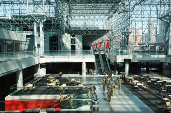 资料图片：美国民警卫队人员在纽约贾维茨会议中心帮助建设“方舱医院”。（法新社）