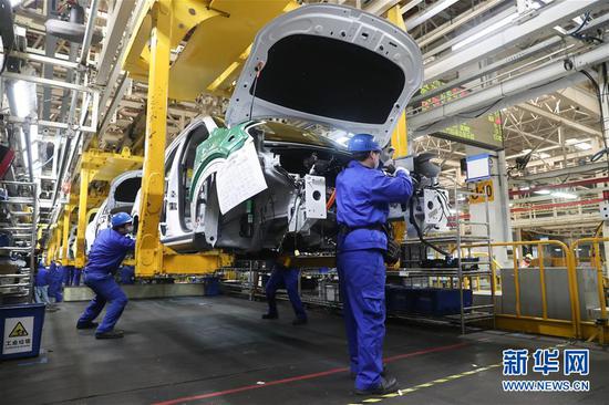工人在上汽临港工厂总装车间生产线上作业（2月27日摄）。新华社记者 丁汀摄