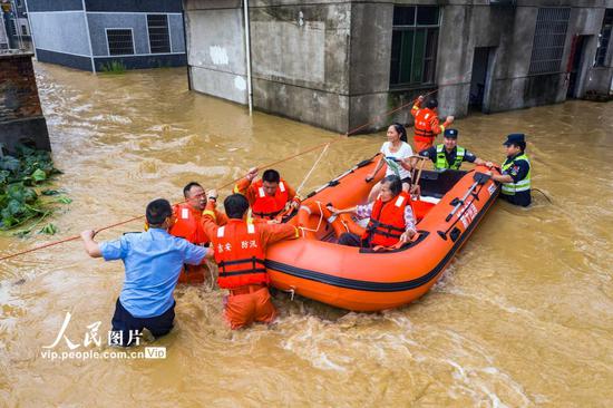 2020年7月10日，江西省吉安市新干县应急救援队正在沂江乡大洲村用皮筏艇转移两名受困群众。

　　（李福孙/人民图片）