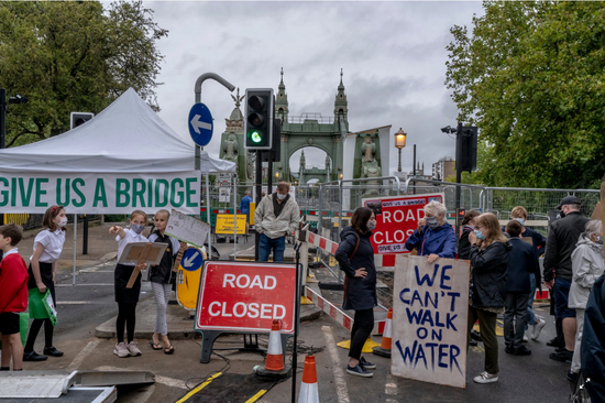 伦敦市民手举“不能在水上行走”等标语，抗议大桥封闭（《纽约时报》图）
