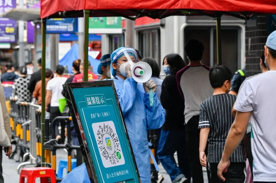 2022年3月13日，志愿者在深圳罗湖区东门广场核酸检测点引导居民。新华社发（储焱摄）