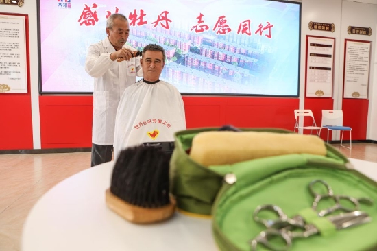 ↑8月18日，在牡丹社区志愿者之家，志愿者为居民免费理发。