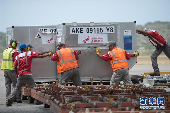 3月29日，在委内瑞拉首都加拉加斯西蒙·玻利瓦尔国际机场，工作人员搬运民生物资。新华社发