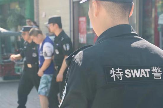 民警押解犯罪嫌疑人指认现场。铜陵警方供图