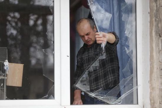 2月24日，顿涅茨克当地居民查看受损的房屋。新华社发