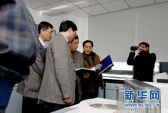 在国家重点实验室评估现场，王逸平研究员（右二）向评估专家们介绍药理仪器使用和共享记录（2011年3月7日摄）。新华社发