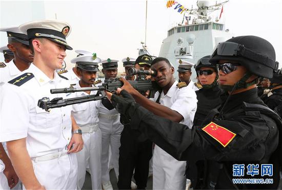2015年8月27日，中国海军152舰编队访问苏丹红海州期间，苏海军学院学员参观济南舰时，亲身体验特战队员的武器装备。新华社发（代宗锋 摄）