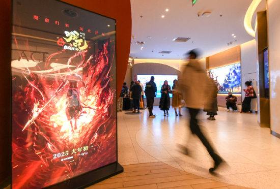 觀眾經過《哪吒之魔童鬧海》海報。新華社記者 唐文豪 攝