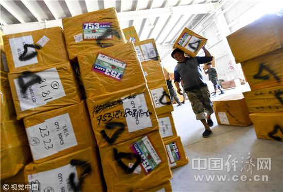 图为距离中哈霍尔果斯国际边境合作中心不远的一处货运仓库，工作人员正在整理货物，准备发往哈萨克斯坦。（图片来源：视觉中国）
