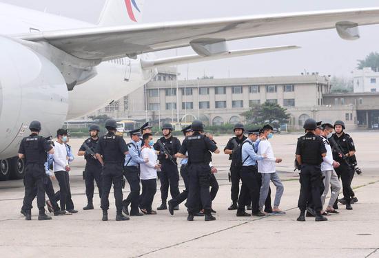  6月7日7时许，一架中国民航包机降落在首都国际机场，94名台湾籍电信网络诈骗嫌疑人被民警从西班牙押解回国。新京报记者 王贵彬 摄