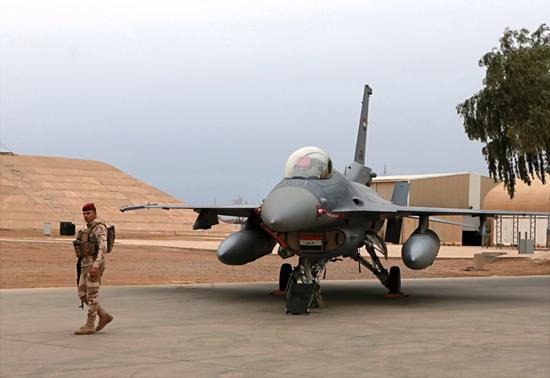 伊拉克巴拉德空军基地内，一名士兵在伊空军F-16IQ战机旁警戒。
