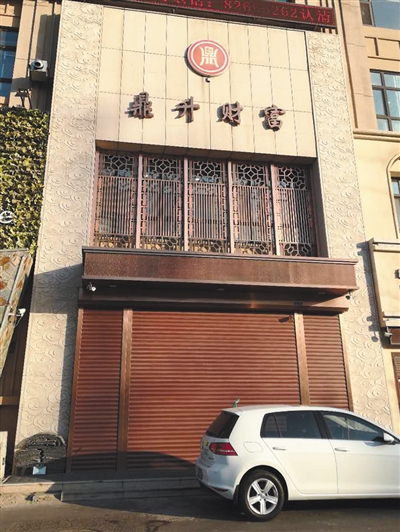 12月10日，位于长春市临河街中海紫御华府的一栋门面楼的正中央，挂着“鼎升财富”四字以及一个商标，商标下的卷帘门紧锁。