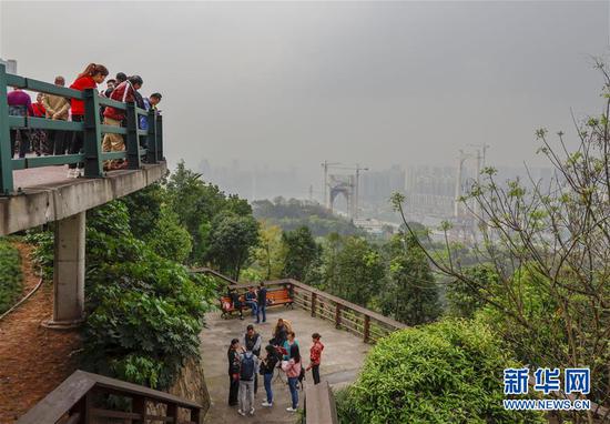 游客在重庆半山崖线步道的虎头岩段游览（4月3日摄）。 新华社记者 刘潺 摄