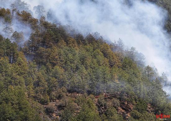 冕宁县森林大火扑火现场，消防队员穿过火场