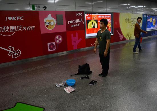 △2011年出狱后,前大运会体操冠军张尚武在街头卖艺。图据 IC Photo