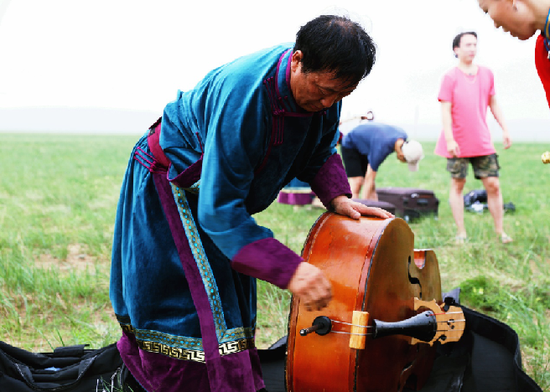 乌力吉图整理乐器(新华网 李倩摄)