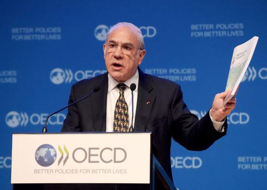 资料图片：11月21日，OECD秘书长古里亚在巴黎总部举行的新闻发布会上发表讲话，介绍了最新的经济展望报告。（法新社）