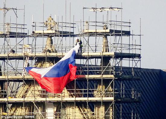 建筑工人将挂在索尔兹伯里大教堂上的俄罗斯国旗取下。（每日邮报）