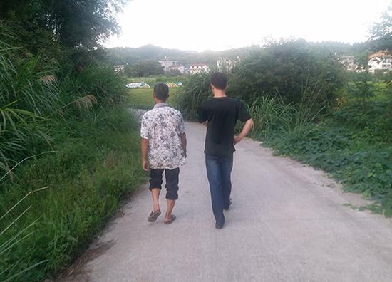 9月17日，杨轩和父亲走在老家路上。