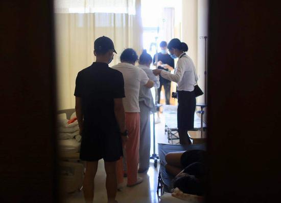 7月23日，家人扶着张天媛上完厕所走回病床。 新京报记者 浦峰 摄