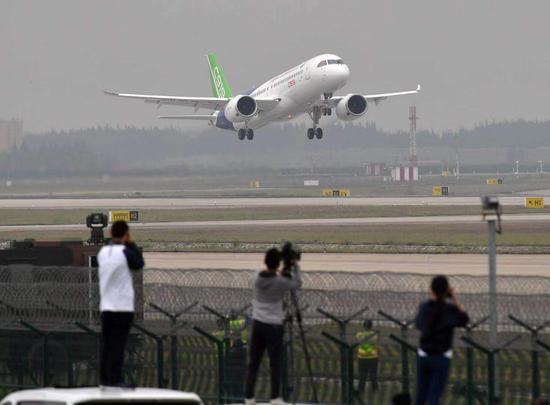 2017年5月5日，飞友在上海浦东机场外侧拍C919首飞。摄影/新京报记者 陶冉