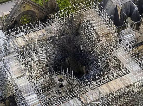 当地时间2019年4月17日，法国巴黎，俯瞰火灾后的巴黎圣母院，屋顶被烧穿出现“大窟窿”，触目惊心。图据IC Photo