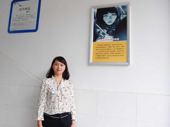 2018年5月29日，在安徽金寨三合实验学校，苏明娟与当年的宣传照片合影。新华社发 王从启摄
