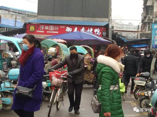 面对疫情，防护要做，年货也要买。图为武汉市蔡甸区最大的菜市场出入口。《等深线》记者 王迎春 摄
