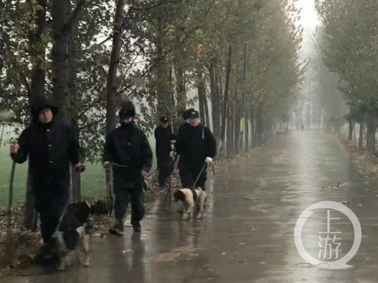 ▲11月17日，民警牵着警犬在包南村搜捕。摄影/上游新闻记者 沈度