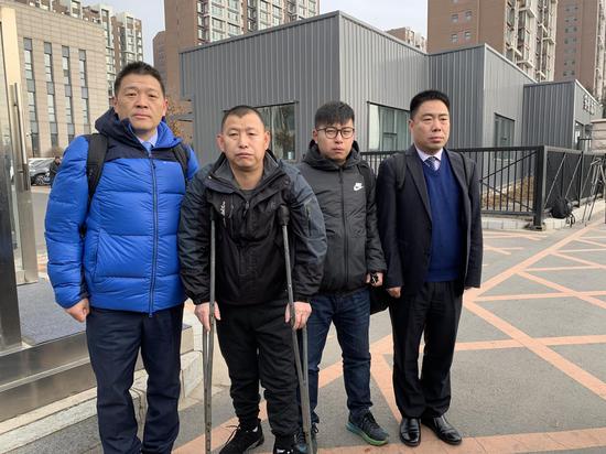 今天上午,金哲宏(左二)在代理律师和儿子的陪同下走出法庭。新京报记者 王巍 摄