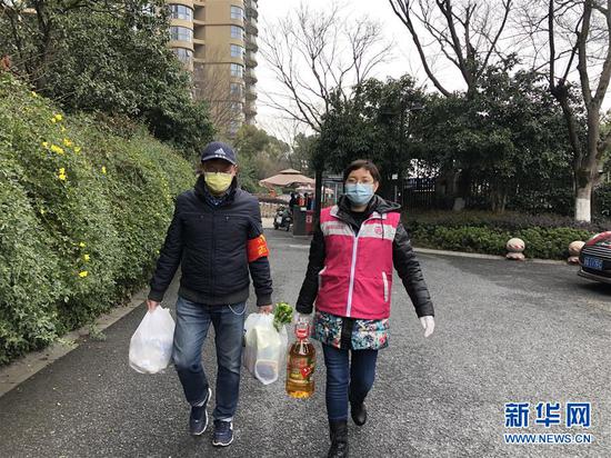 3月2日，杭州市四季青街道钱塘社区工作人员和志愿者给隔离户送生活物资。新华社发