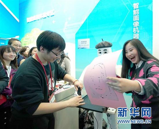 ↑11月29日，一位参观者在看到智能画像机器人为自己“创作”的画像后开怀大笑。当日，在北京国家博物馆举行的“伟大的变革——庆祝改革开放40周年大型展览”迎来参观高峰，单日观众人数超过5万人次。 新华社记者陈建力摄