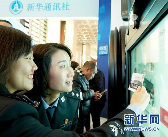 ↑11月29日，参观者在新华社展区进行定制明信片互动体验。 新华社记者陈建力摄