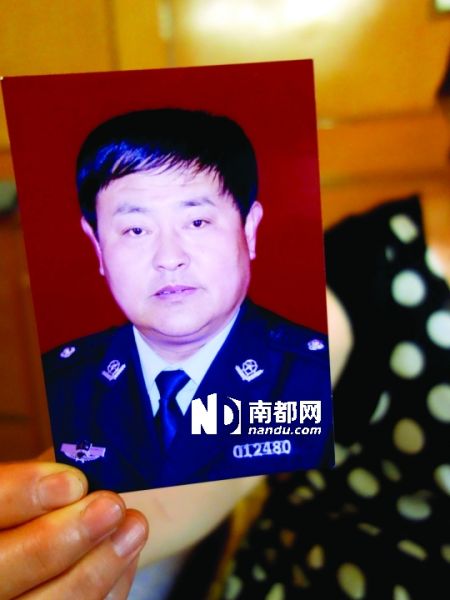 刘国民的妻子展示丈夫生前照片。孙旭阳 摄