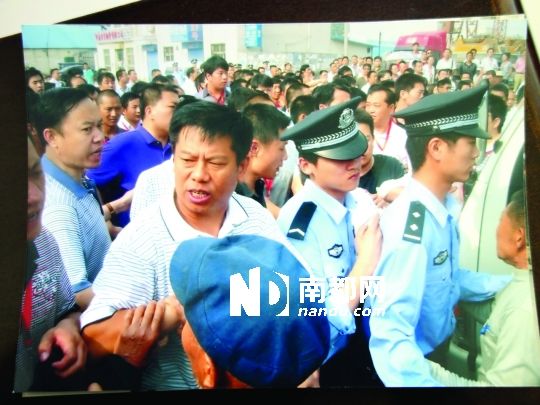 3年前的拆迁现场。拆迁队正跟村民在刘大孬驾驶的白色货车(图右侧)前理论。村民供图