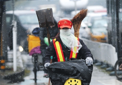 昨日北京迎来第二场雪，方庄街头，一位环卫工人雪中骑车。新京报记者 尹亚飞 摄