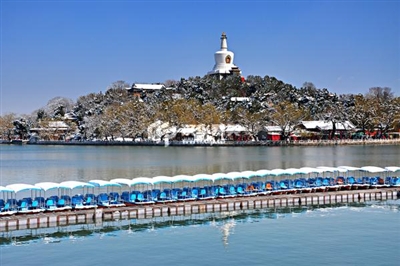 北海公园
湖水映白塔犹如天然画卷
琼华岛白塔巍峨壮观，五彩琉璃瓦搭配散落的雪花，犹如一幅天然山水画卷。同时，北海正在举行菊花展，雪后盛开更显灵动，展览时间到11月25日。
图/CFP