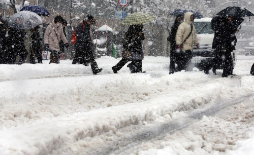 人们冒着大雪小心翼翼行走。