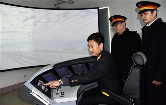 吕向阳（左）在济南机务段高铁驾驶舱模拟工作室给学员做辅导（1月29日摄）。新华社记者 周科/摄