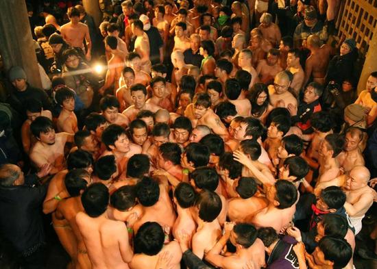 图为一群男子一齐向前涌，激烈的争夺。（网站截图）