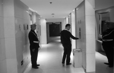 酒店内安防升级，一名保安守在电梯前。
